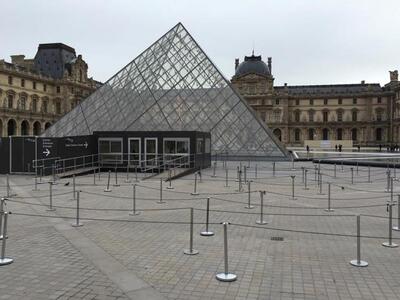 The entrance of the Louvre is seen deser...