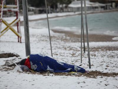 Ο άστεγος που κοιμάται στην χιονισμένη π...