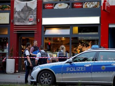 Police stand outside where a 21-year-old...