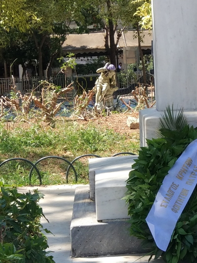 Με φόντο πίσω του, τον αυλητή στο σιντριβάνι. Ο οποίος επί ενάμιση αιώνα αδειάζει νερό, εσχάτως δε, το κάνει έχοντας όμορφη μοβ ή μοβοροζέ κώμη…