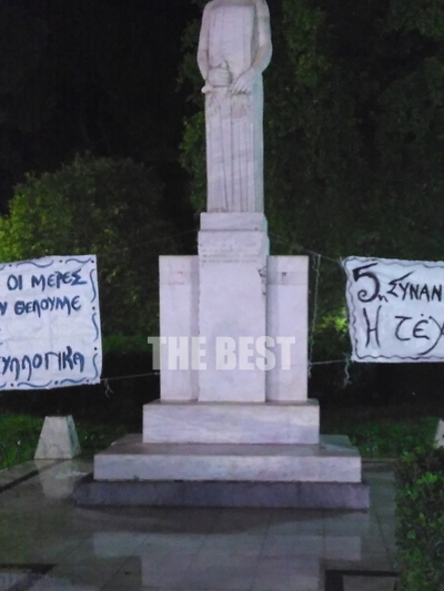 Κάποιες άλλες φορές το άγαλμα αποκτά κι άλλες χρήσεις, πως να το πούμε, γίνεται πιο χρηστικό, πιο ωφέλιμο για την πόλη. Χρησιμεύει, για παράδειγμα, στο να στερεώνονται διάφορα αεροπανό. Το δένουμε με τα σκοινιά και κάνουμε τη δουλειά μας. Πάτρα 2 Δεκεμβρί