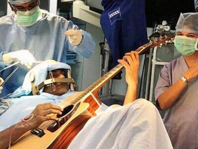 Ινδός παίζει κιθάρα την ώρα που εγχειρίζ...